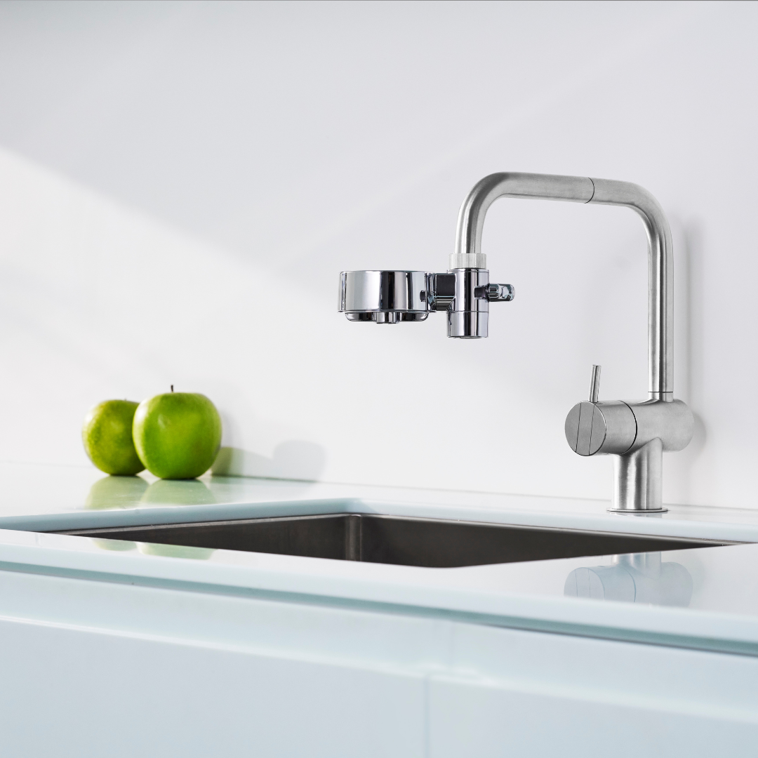 Chrome EcoPro Compact tap water filter fitted to a stainless kitchen tap above a white benchtop